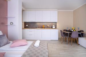 a room with a bed and a kitchen with a table at MyFlat Siófok Beach Wellness Apartment in Siófok
