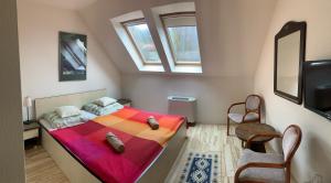 a bedroom with a bed with a colorful blanket at Tündérszikla Panzió in Pilisjászfalu