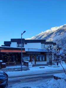 ein Gebäude auf einer Straße mit Schnee auf dem Boden in der Unterkunft Chamonix centre - WIFI - Parking - Rés Aiguille du midi in Chamonix-Mont-Blanc
