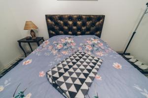 a bed with a blue comforter with flowers on it at Sreckovic Apartmani 1 in Kragujevac