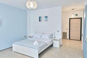 ein Schlafzimmer mit einem weißen Bett mit einem Teddybär darauf in der Unterkunft Sea Shore apartments - Spa n Pools beach resort in Mamaia