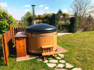 a large wooden tub with a bench next to a fence at Casa Violetta B&B in Agrate Conturbia