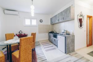 a kitchen and dining room with a table and a stove at Sreckovic Apartmani 1 in Kragujevac
