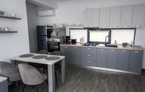 a kitchen with gray cabinets and a table and chairs at apart bun in Oradea
