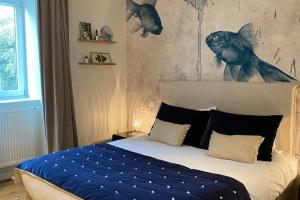 ein Schlafzimmer mit einem Bett mit einem Wandbild aus Fisch in der Unterkunft Villa Saint Raphaël in Saint-Malo