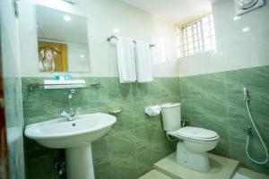 uma casa de banho com um lavatório, um WC e um espelho. em Jatra Flagship Sylhet City Centre em Sylhet