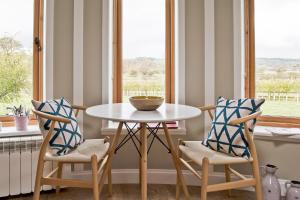 a dining room with a table and two chairs at Nether Farm Roundhouses - Henmore Water & Sturston Winds with hot tubs - Bradley Wood no hot tub in Ashbourne