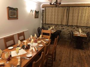 Lewdown的住宿－Blue Lion Inn，用餐室配有长木桌子和椅子