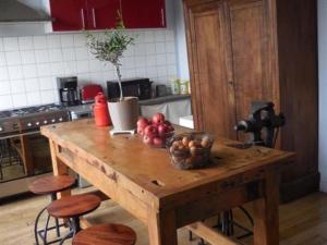 einen Holztisch in einer Küche mit einer Schale Obst in der Unterkunft Gite Cottage d'Hamicourt aux Portes de la Baie de Somme in Hamicourt