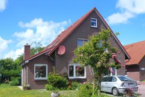 a house with a car parked in front of it at Ferienwohnungen im Haus Herrmann in Neuharlingersiel