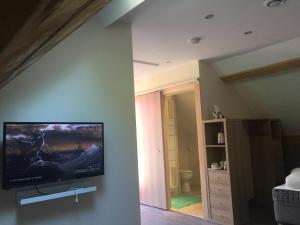 a living room with a flat screen tv on a wall at Beauval Chambre in Seigy