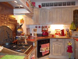 a kitchen with wooden cabinets and a stove top oven at Au Soleil Levant Homestay in Sarlat-la-Canéda