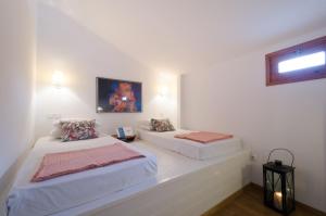 2 camas en una habitación con paredes blancas en Villa Sokaki, en Lindos