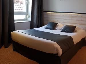 a large bed with two pillows in a bedroom at L'Usine in Belval