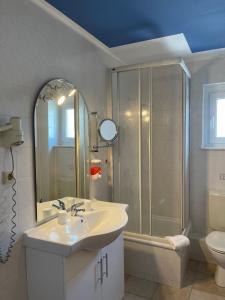 Un baño blanco con lavabo y ducha. en Aparthotel HAUS USEDOM, en Kolpinsee 122 fotos más