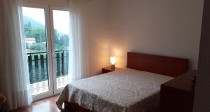 a bedroom with a bed and a large window at Casa Marciana in Geres +11 photos