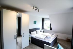 a hotel room with a bed and a mirror at Blaue Huis in Wenningstedt
