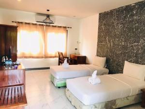une chambre d'hôtel avec deux lits et un canapé dans l'établissement PTK BEACH, à Chaweng