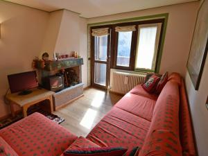 a living room with a red couch and a fireplace at Villa al Campo in Madonna di Campiglio