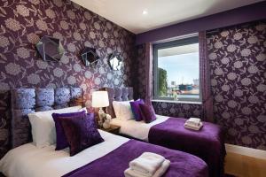 ゴールウェイにあるSea View Luxury City Centre - Best Locationの紫色の壁の部屋にベッドが2つある