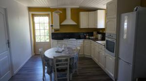 een keuken met een tafel met stoelen en een koelkast bij Des vacances à 4 à Talmont St Hilaire in Talmont