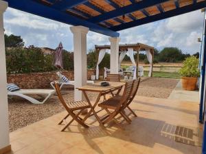 un patio con mesa y sillas bajo una pérgola en Villa Marta Formentera, en Sant Ferran de Ses Roques
