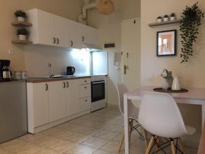 a kitchen with white cabinets and a table and chairs at Nikoletta's Studio 2 in Komotini