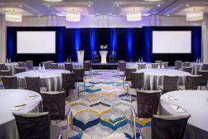 um salão de banquetes com mesas e cadeiras brancas em Hyatt Regency Boston Harbor em Boston