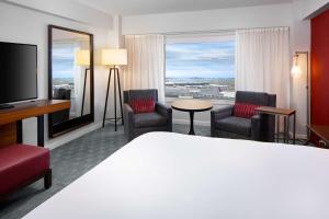 a hotel room with a bed and chairs and a large window at Hyatt Regency Boston Harbor in Boston