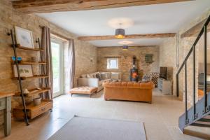 un soggiorno con pareti in mattoni e divano di Middle Barn a Dyrham