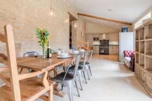 cocina y comedor con mesa de madera y sillas en Middle Barn en Dyrham