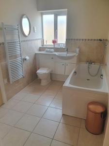 La salle de bains est pourvue d'une baignoire, de toilettes et d'un lavabo. dans l'établissement Harbour Beach Apartment, à Pevensey