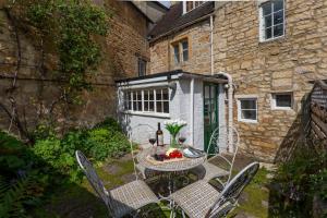 a patio with a table and chairs and a building at Millers Cottage in Chipping Campden