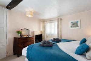 a bedroom with a large bed with two teddy bears on it at Millers Cottage in Chipping Campden