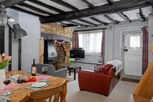 ein Wohnzimmer mit einem Tisch und ein Zimmer mit einem Kamin in der Unterkunft Millers Cottage in Chipping Campden