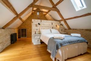 una camera da letto con un letto grande in una mansarda di Middle Barn a Dyrham