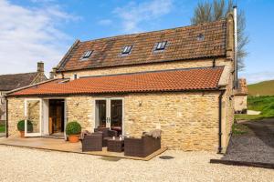 an old stone house with a patio in front of it at Middle Barn in Dyrham