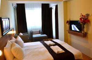 a hotel room with a large bed and a television at Park Lakeside Ohrid in Ohrid