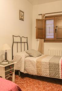 a bedroom with two beds and a table and a window at Vivienda rural Moraima in Capileira