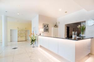 a kitchen with white cabinets and a counter with flowers at Trip Inn Hotel Astoria in Göttingen