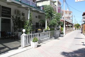 a white fence in front of a building at Lena Studios in in Hanioti