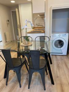 a glass table with two chairs and a washing machine at Fuencarral Apartments in Madrid