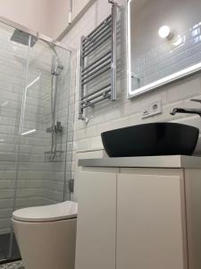 uma casa de banho com um lavatório e uma cabina de duche em vidro. em Fuencarral Apartments em Madri