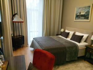 a hotel room with a bed and a red chair at Dom Sivre Boutique Hotel in Samara