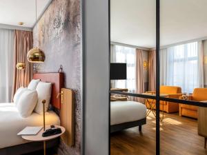 a hotel room with a bed and a desk at Mercure Saint Omer Centre Gare in Saint-Omer