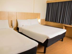 ein Hotelzimmer mit 2 Betten und einem Fenster in der Unterkunft ibis Maceio Pajuçara in Maceió