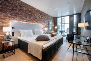Un dormitorio con una cama grande y una pared de ladrillo. en Solo Sokos Hotel Lahden Seurahuone, en Lahti