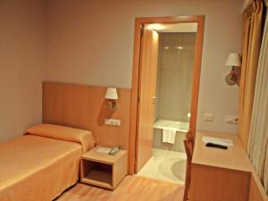 a bedroom with a bed and a bathroom with a tub at Hotel Windsor in Santiago de Compostela