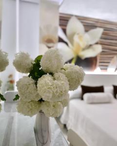 a vase filled with white flowers on a table at El Jardin in Soto de la Marina