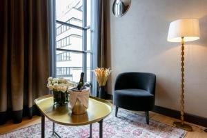 - un salon avec une table, une chaise et une fenêtre dans l'établissement Solo Sokos Hotel Lahden Seurahuone, à Lahti